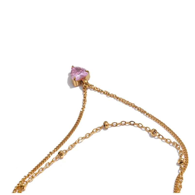 Gold bracelet with a pink gemstone on a white background