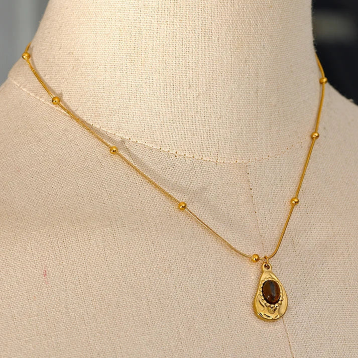 Gold necklace with a pendant on a mannequin bust