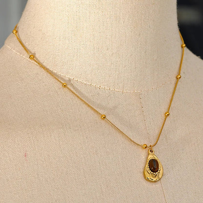 Gold necklace with a pendant on a mannequin bust